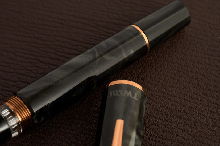 This TWSBI Obsidian fountain pen is made of a dark grey/black swirled acrylic resin, inspired by the natural obsidian stone. The pen is complemented by rose gold-plated trim and is equipped with a rose gold-plated stainless-steel nib.

Pen cap is&nbsp;able to post&nbsp;onto the back of the pen

Piston Filler Fountain pen.
Simply unscrew the end cap, dip into ink, screw back the end cap, and you're done! Ready to write!!