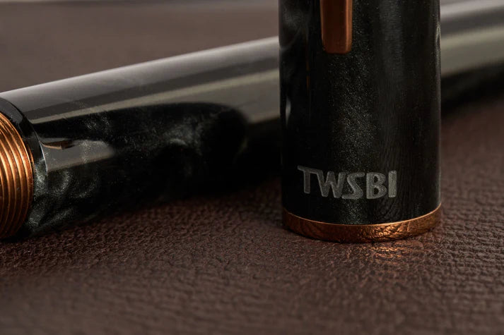 This TWSBI Obsidian fountain pen is made of a dark grey/black swirled acrylic resin, inspired by the natural obsidian stone. The pen is complemented by rose gold-plated trim and is equipped with a rose gold-plated stainless-steel nib.

Pen cap is&nbsp;able to post&nbsp;onto the back of the pen

Piston Filler Fountain pen.
Simply unscrew the end cap, dip into ink, screw back the end cap, and you're done! Ready to write!!