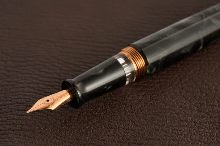 This TWSBI Obsidian fountain pen is made of a dark grey/black swirled acrylic resin, inspired by the natural obsidian stone. The pen is complemented by rose gold-plated trim and is equipped with a rose gold-plated stainless-steel nib.

Pen cap is&nbsp;able to post&nbsp;onto the back of the pen

Piston Filler Fountain pen.
Simply unscrew the end cap, dip into ink, screw back the end cap, and you're done! Ready to write!!