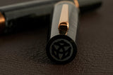 This TWSBI Obsidian fountain pen is made of a dark grey/black swirled acrylic resin, inspired by the natural obsidian stone. The pen is complemented by rose gold-plated trim and is equipped with a rose gold-plated stainless-steel nib.

Pen cap is&nbsp;able to post&nbsp;onto the back of the pen

Piston Filler Fountain pen.
Simply unscrew the end cap, dip into ink, screw back the end cap, and you're done! Ready to write!!
