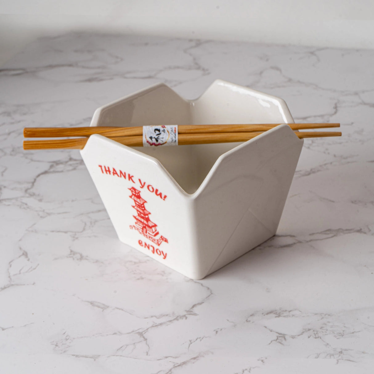 Everything tastes better in a to-go container…but this one is designed to be reusable

Bowl Size: 5" Dia x 4"H
Chopsticks 9"L
Capacity: 16 fl oz
Material: Ceramic
Microwave and Dishwasher Safe
Origin: China