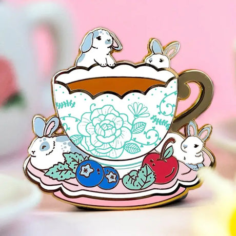 These pastel bunnies are spending a relaxing day amongst blueberries, cherries, and yummy tea inside an intricately decorated cup.

✦ Hard enamel
✦ Shiny gold metal
✦ 1.75 inches
✦ 2 Posts for extra security
✦ Rubber backings
✦ Back stamped for authenticity

Comes packaged on a backing card.