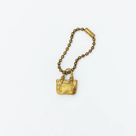 Brass charm in the shape of an engineer tote bag.

Equipped with a sleek ball chain, it attaches effortlessly to your bags, pouches, or key rings. Despite its petite size, it brings the distinct, rich texture and unmistakable presence that only genuine brass can provide.

As you use it, the brass will develop a natural patina over time—enjoy the changing character that comes with age.

Color: The color you see on your screen may differ from the actual product.

Brass Products

Due to the nature of brass, so