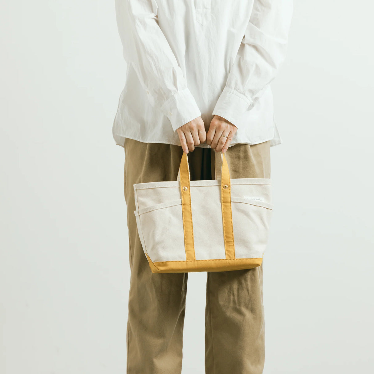 The SUPERIOR LABOR Mini Tote Bag

A simple, timeless canvas bag designed for everyday life.

Its compact size is just right for daily essentials, while the four outer pockets keep your glasses, keys, favorite pens, or notebook neatly organized.

They make it easy to stay tidy and add a touch of extra storage without changing the clean look of the bag.

Size: W37×H23.5×D12.5cm
Canvas Products
Painted areas may be affected by friction or water, which can cause color transfer. Please handle with care.