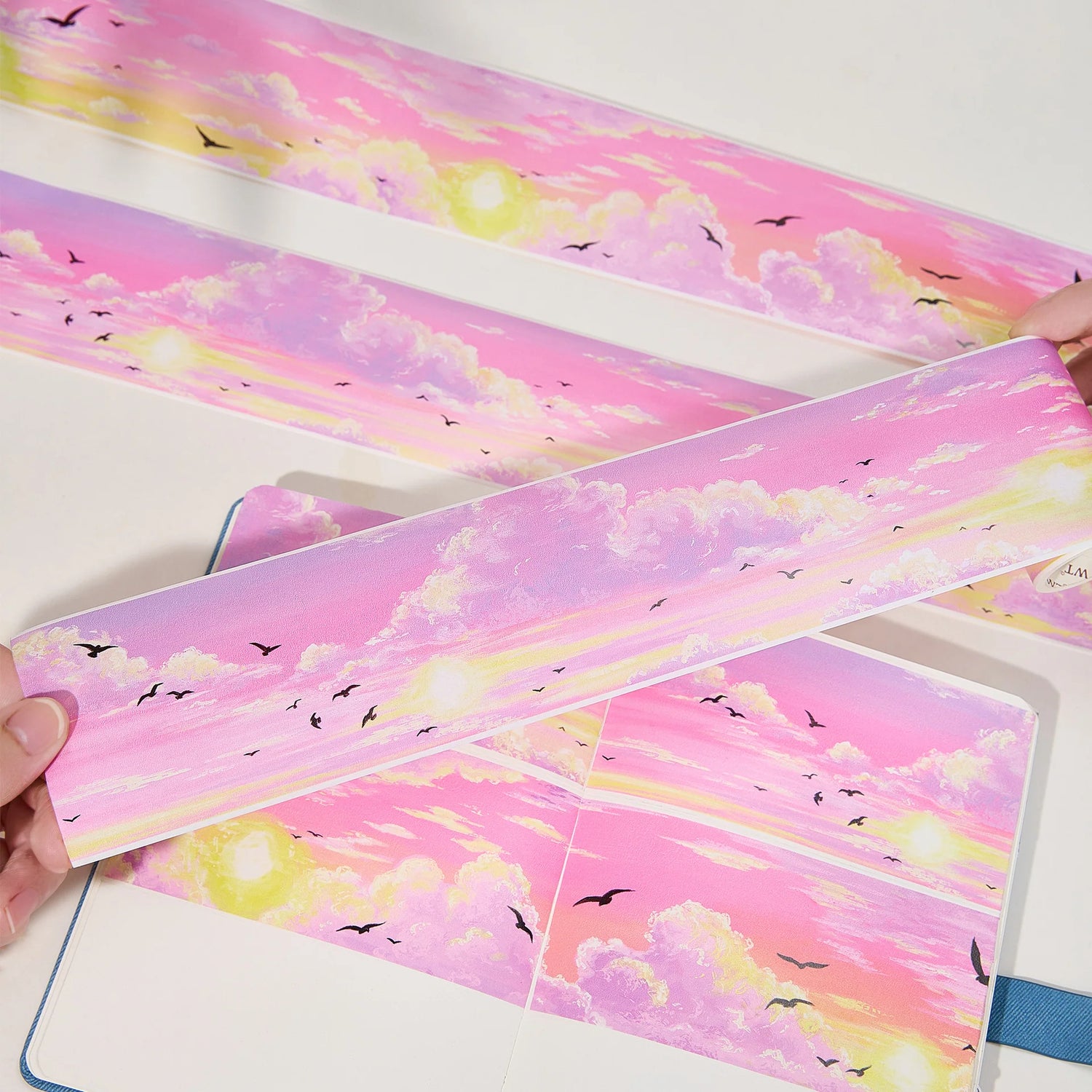 Capture the gentle embrace of evening with the Lotus Twilight Wide Washi/PET Tape. This tape embodies the softest part of the sunset. The design features a dreamy, seamless gradient that flows from a warm, glowing orange into a hazy, light lavender. Drifting through this pastel sky is a flock of silhouetted birds, gliding peacefully on the breeze. It brings a sense of calm and whimsy to your journal, perfectly replicating that quiet, cotton-candy sky moment just before the stars come out.