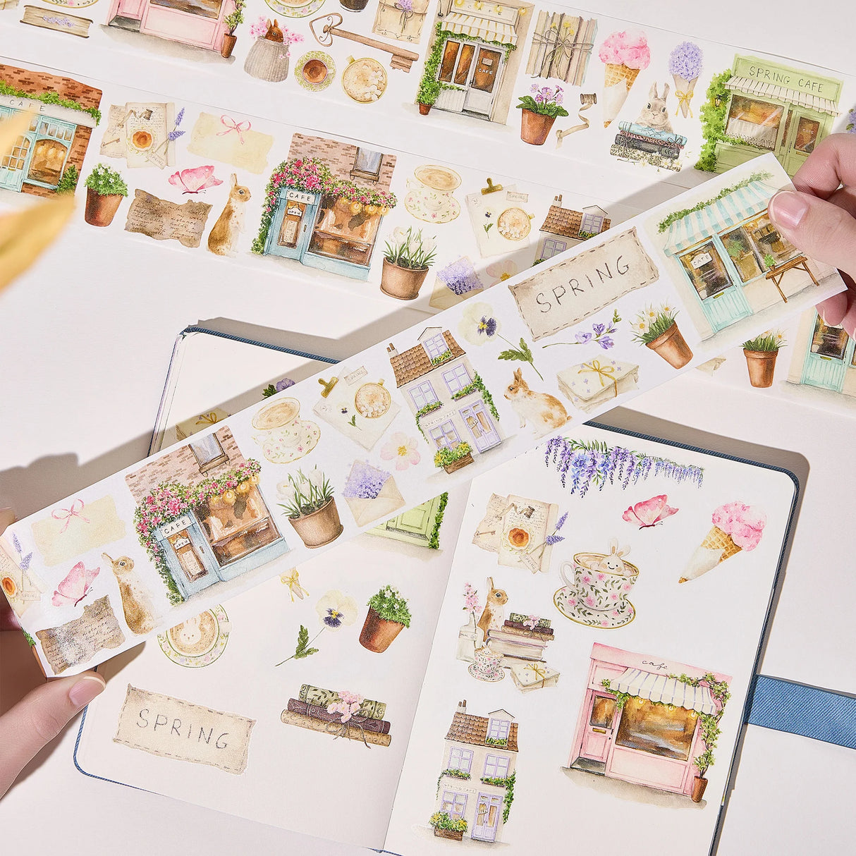 Celebrate the season of new beginnings with a design that marries architecture and nature. Our Spring Café Wide Tape is a watercolor love letter to the season, featuring quaint cafe facades almost hidden behind explosions of pastel bouquets and greenery.