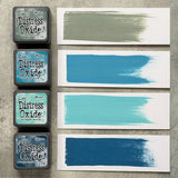 Tim Holtz Distress Mini Oxide Ink Pads are a collection of 1 x 1 cubes featuring water-reactive dye &  pigment ink fusion that creates an oxidized effect when sprayed with water.