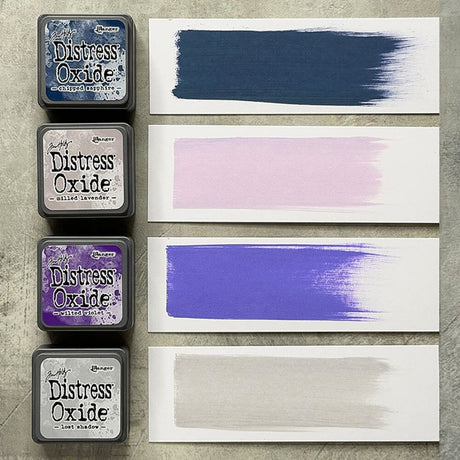 Tim Holtz Distress Mini Oxide Ink Pads are a collection of 1 x 1 cubes featuring water-reactive dye &  pigment ink fusion that creates an oxidized effect when sprayed with water.