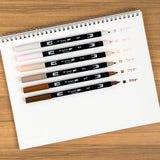 Set of 6 colors. Dual Brush Pens feature a flexible brush tip and a fine tip in one marker. The brush tip works like a paintbrush to create fine, medium, or bold strokes, while the fine tip provides consistent lines. The Coffee Break palette is inspired by rich coffee tones and warm neutrals, perfect for cozy and inviting designs. The water-based ink is blendable, and the resilient nylon brush retains its point stroke after stroke.