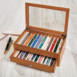 Solid wood box to display and protect up to 20 pens. Our True Writer Pen Box offers space to hold 10 pens in the top case and 10 additional pens in the bottom drawer, lined with suede to protect your precious pens from scratches. The glass top allows you to see and display your beautiful collection. It makes the perfect gift for the pen collector and aficionado. Make it personal with a monogram on the glass lid.