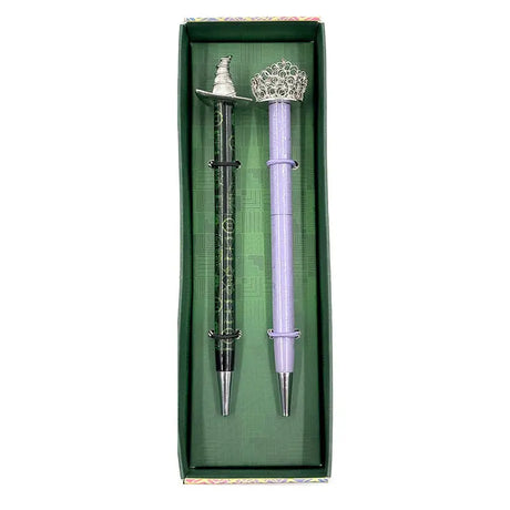 Celebrate your love of Wicked with this set of two ballpoint pens, perfect to use for writing notes, spells, or letters home from your time at Shiz University.

DETAILED DESIGN: This deluxe set contains two ballpoint pens with designs inspired by both Elphaba and Glinda. Each pen features a detailed silver, die-cast metal topper of Elphaba hat and Glinda’s crown.&nbsp;

PERFECT FOR FANS: This pen set makes a wonderful gift and is a perfect way to show your love for Wicked and the beloved characters of Elpha