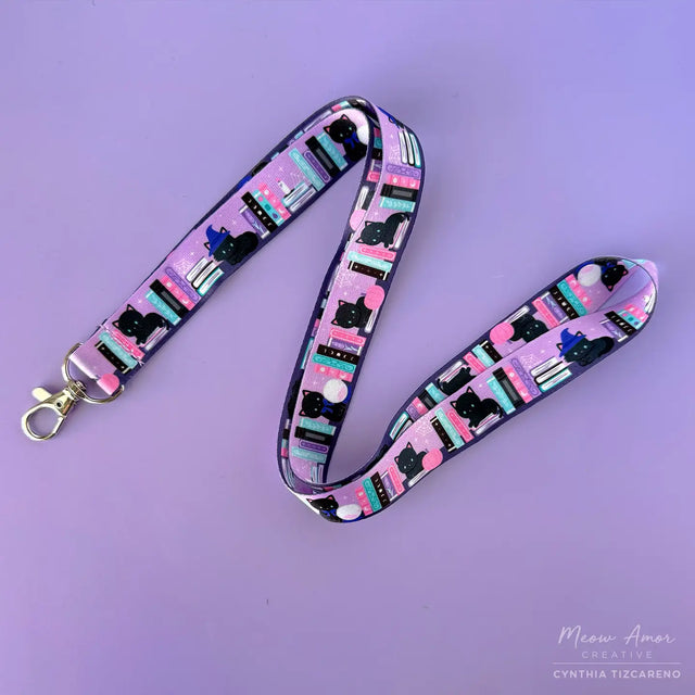 Bookish Witch Cat Lanyard. This purple lanyard features witch cats and books, perfect for all cat lovers out there. Show off your love for felines while keeping your items secure and easily accessible.

2cm X 95cm
double-sided printing
Swiveling Lobster Clasp
