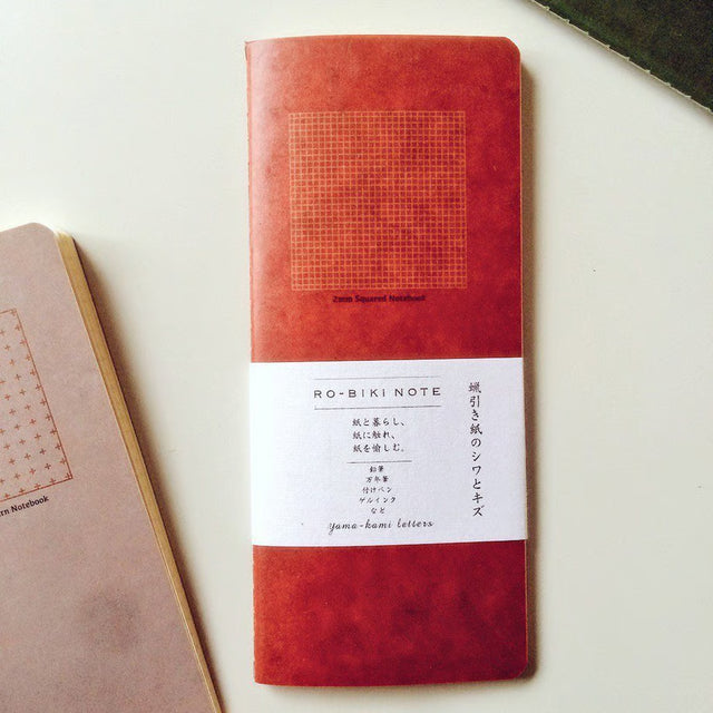 The RO‑BIKI Note is a beautifully crafted Japanese notebook known for its distinctive waxed paper cover, which gains character the more you use it. Over time, the cover softens, develops a natural patina, and becomes uniquely yours—making every notebook feel personal and well‑loved.

Inside, you’ll find high‑quality 2mm square grid paper ideal for writing, sketching, planning, or journaling. Its compact size makes it perfect for everyday carry, while the durable construction ensures it holds up to frequent 