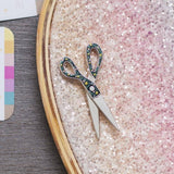 Pin de esmalte interactivo con forma de tijeras